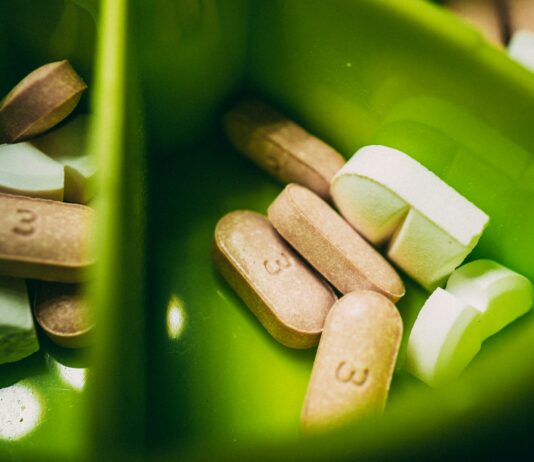 여름철 운동 후 회복 방법 white medication pill on green plastic container