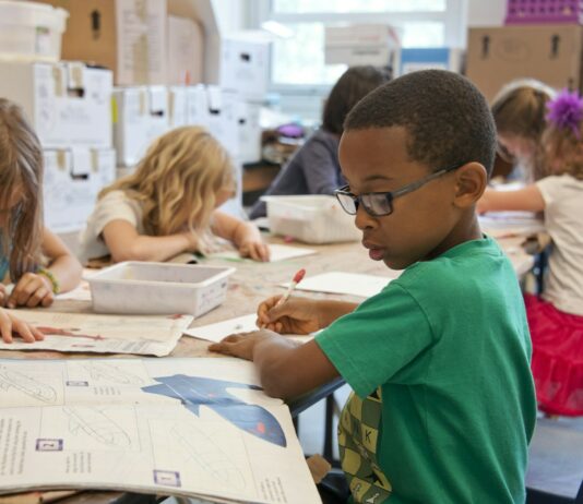 2학기부터 ‘늘봄학교’ 전국 운영…“초1 돌봄 대기 완전 해소” boy in green sweater writing on white paper