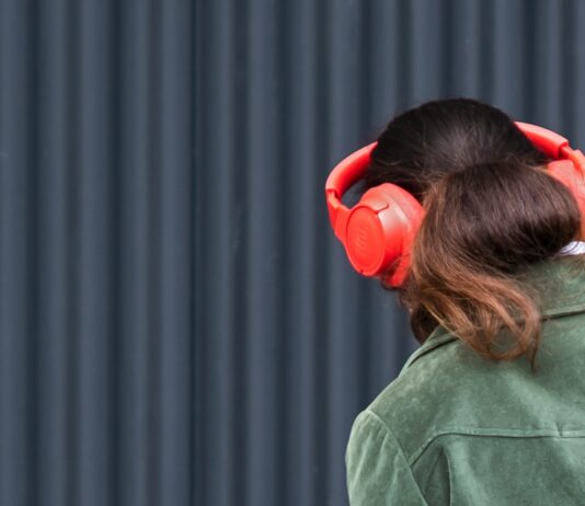 음악 감상으로 겨울 스트레스 날리기 a woman wearing red headphones and a green jacket