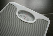 건강을 위한 동반자로서 다이어트와 운동 a bathroom scale sitting on top of a wooden table