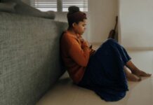 스트레스에 지친 현대인, 정신건강의 중요성 다시 생각해볼 때 man in orange long sleeve shirt sitting on gray couch