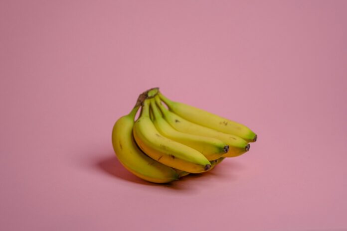 yellow banana fruit on pink surface