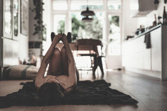 Photo by Peyman Shojaei a woman laying on the floor in a kitchen