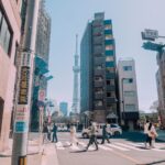 걷기 한 번, 건강 두 번 챙긴다…일상 속 똑똑한 ‘걷기 루틴’ 트렌드 People crossing street with tall tower in background