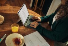 집에서 쉽게 따라하는 마인드풀 식사, 건강하게 먹는 새로운 습관 Woman typing on laptop at wooden table with breakfast.