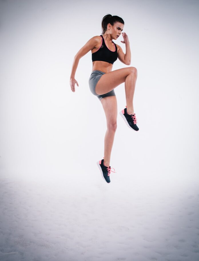 Photo by Clem Onojeghuo woman jumping near white wall paint